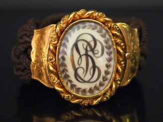 Vente aux enchères Bracelet manchette XIXème en or jaune et cheveux tressés, à décor en s