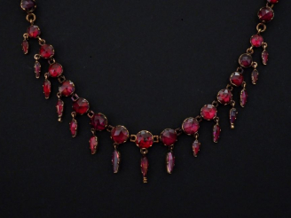 Vente aux enchères Collier draperie en or jaune et grenats disposés en chute et agrementé
