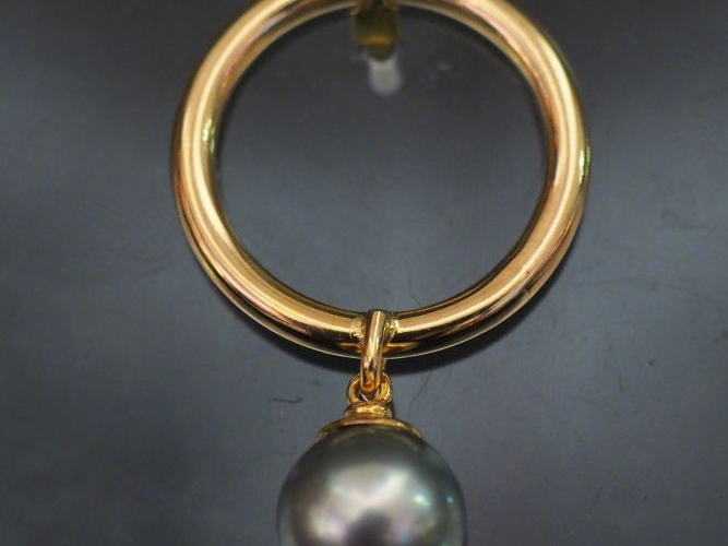 Pendentif en or jaune, à décor d'une perle grise en pendeloque. Poids 