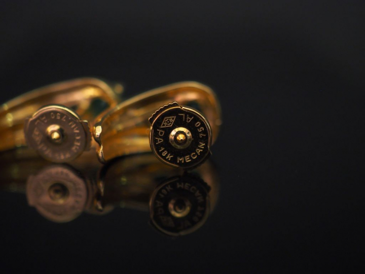 Paire de perce-oreilles en or jaune, sertis de deux émeraudes dont une