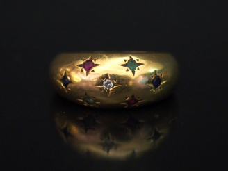 Vente aux enchères 	Bague jonc en or jaune, sertie de six pierres de couleur et d’un peti