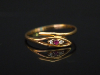 Vente aux enchères 	Petite bague en or jaune de forme stylisée, sertie en son centre d’un