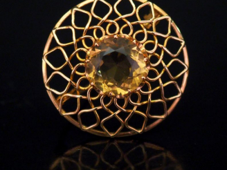Vente aux enchères Broche circulaire en or jaune, à décor ajouré et sertie en son centre 