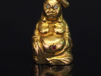 Vente aux enchères 	Pendentif en or jaune figurant bouddha, les yeux sertis d’éclats de d