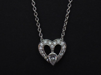 Vente aux enchères Pendentif et sa chaine en or blanc, en forme de cœur serti de petits d