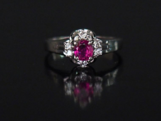 Vente aux enchères 	Bague en platine, sertie en son centre d’un rubis entouré de quatre p