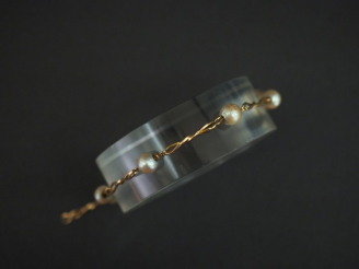 Vente aux enchères Bracelet en or jaune, à décor de maillons torsadés alternés de perles.