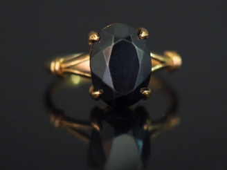 Vente aux enchères Bague en or jaune, sertie en son centre d’une pierre noire facettée.  