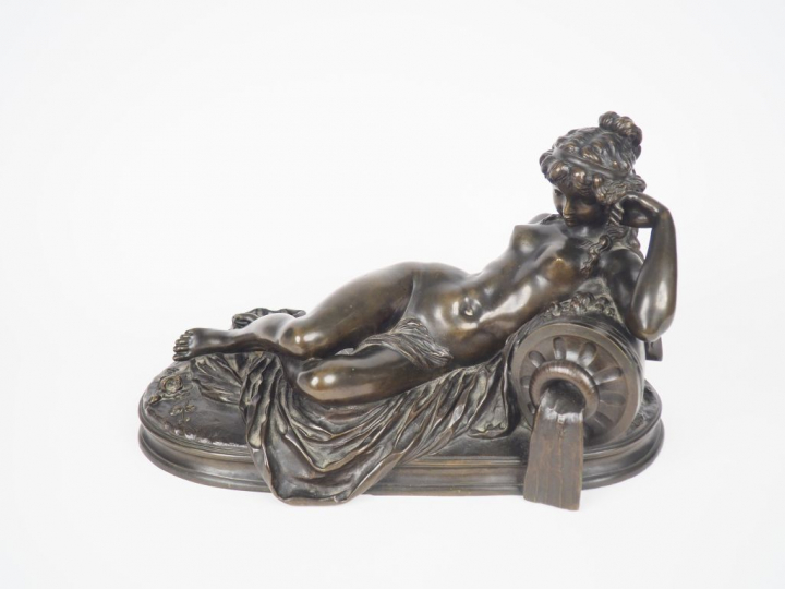 CLODION. "Jeune fille nue allongée". Sculpture en bronze à patine vert