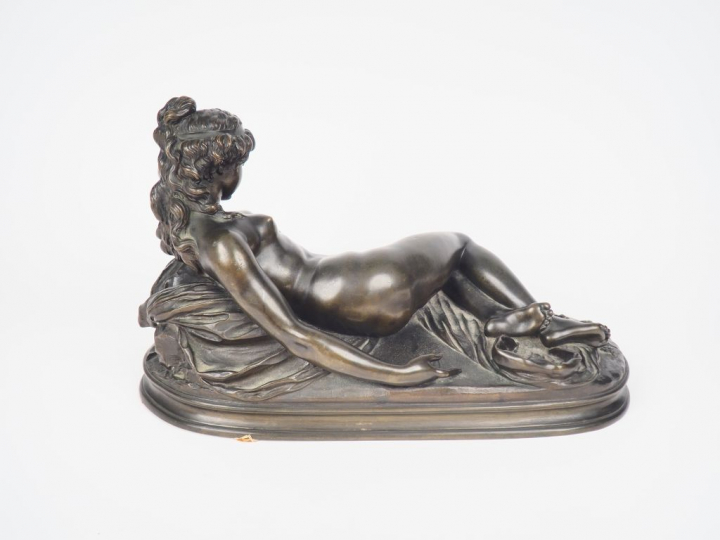 CLODION. "Jeune fille nue allongée". Sculpture en bronze à patine vert