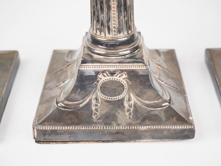 Suite de quatre bougeoirs de style Louis XVI en argent, futs cannelés 