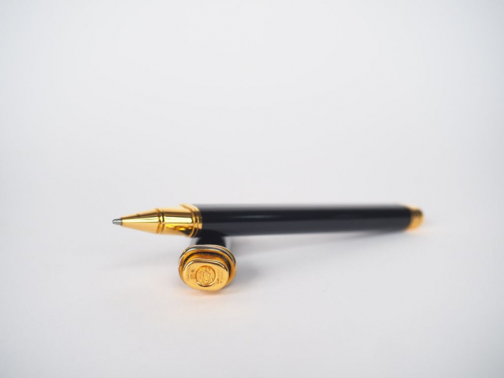 CARTIER, Must de. Stylo bille en résine noir et plaqué or.  Signé. Num