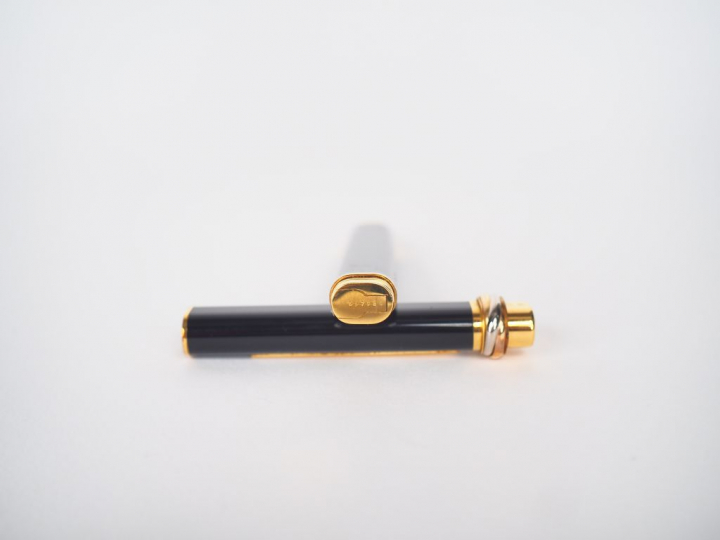 CARTIER, Must de. Stylo bille en résine noir et plaqué or.  Signé. Num
