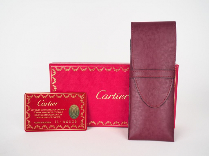 CARTIER.  Etui en cuir bordeaux. Fermeture à rabat.  Monogramme de la 