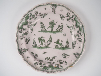 Vente aux enchères MOUSTIERS. Plat XVIIIème en faïence à décor en camaïeu vert de trois g