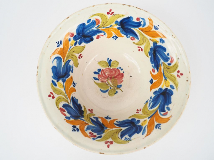 Grande coupe sur talon début XIXème en faïence à décor de fleurs polyc