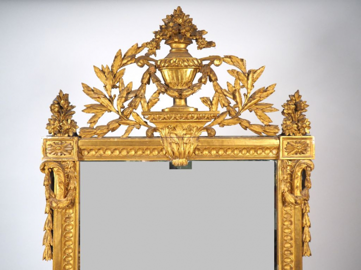 Glace de cheminée Louis XVI en bois sculpté et doré, à décor d'oves et