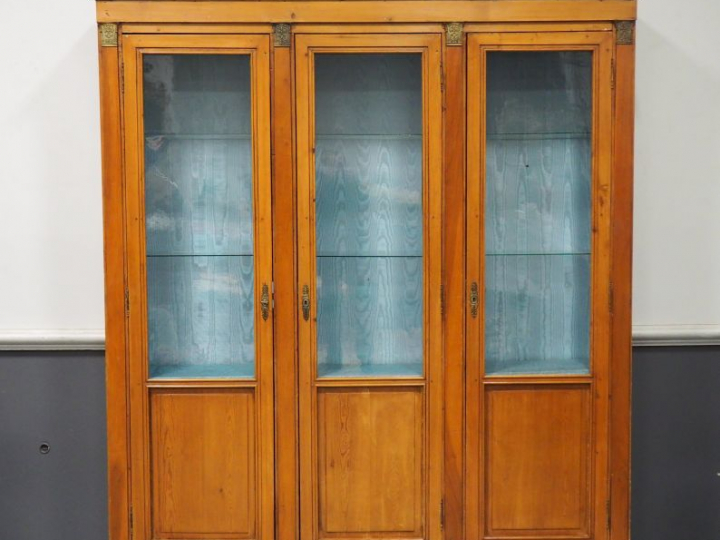 Vitrine de style Empire, en bois naturel, ouvrant à trois portes vitré