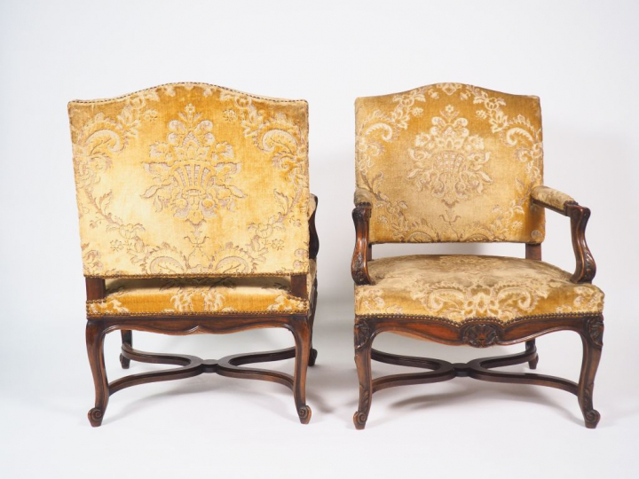 Paire de fauteuils de style Régence en noyer mouluré et sculpté, accot