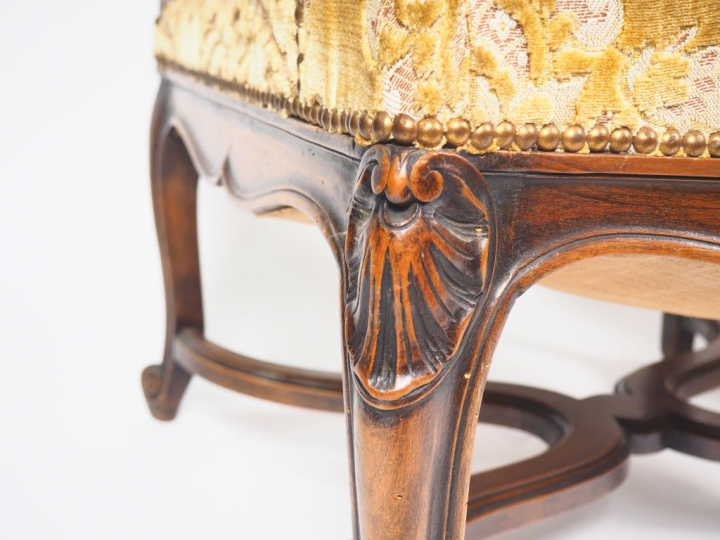 Paire de fauteuils de style Régence en noyer mouluré et sculpté, accot