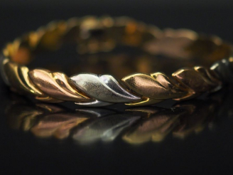 Vente aux enchères Bracelet articulé trois tons d’or, à décor de frise de feuillage. Long