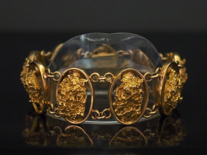Bracelet articulé en or jaune, composé de neuf maillons ovales, sertis