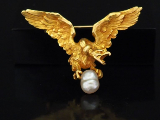 Vente aux enchères Broche en or jaune figurant un aigle aux ailes déployées tenant entre 