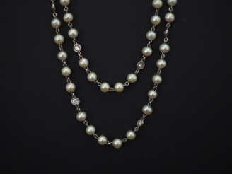 Vente aux enchères Sautoir en or blanc, composé de perles blanches et diamants alternés. 