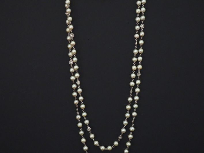 Sautoir en or blanc, composé de perles blanches et diamants alternés. 