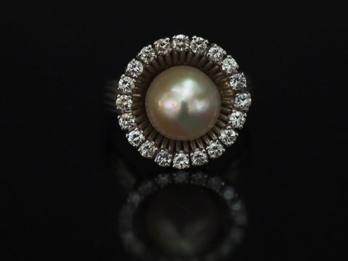 Bague ronde en or blanc, sertie en son centre d'une perle blanche ento