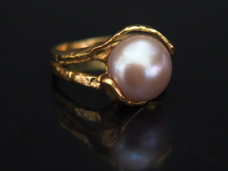 Vente aux enchères Bague de forme stylisée en or jaune, sertie en son centre d'une perle 