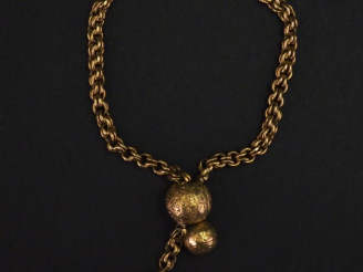 Vente aux enchères Bracelet souple en or jaune, maille forçat, agrémenté de deux boules e