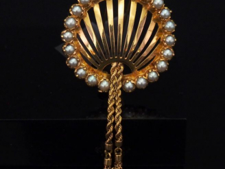 Vente aux enchères Broche ajourée en or jaune, à décor de deux pompons en pendeloques et 