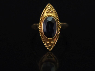 Vente aux enchères Bague de forme marquise en or jaune, sertie en son centre d’un saphir.