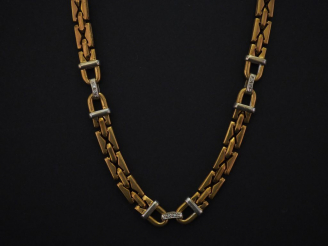 Vente aux enchères 	Collier articulé deux tons d’or, maille plate. Les motifs du centre a