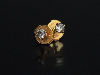 Vente aux enchères 	Paire de puces d’oreilles en or jaune, serties en leur centre d’un pe
