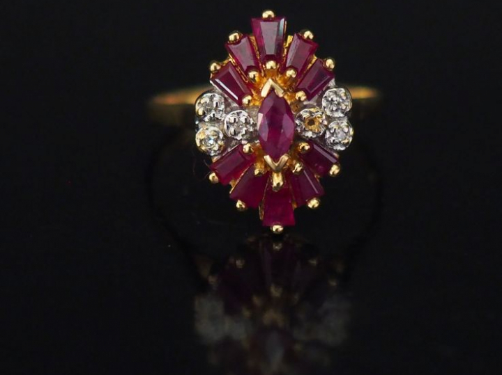 Bague en or jaune de forme stylisée, sertie de rubis calibrés et petit