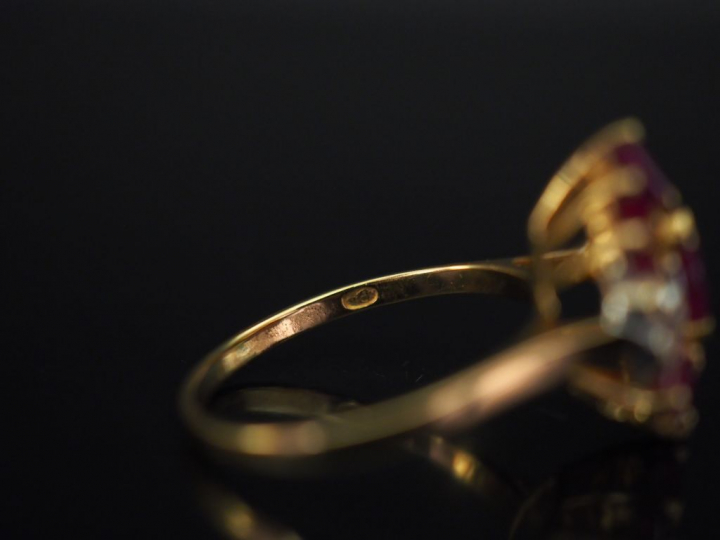 Bague en or jaune de forme stylisée, sertie de rubis calibrés et petit