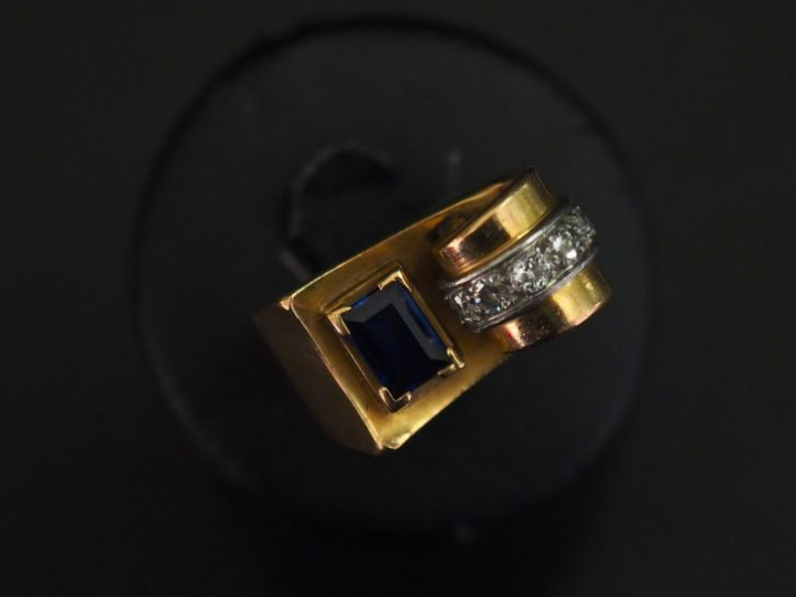 Bague tank en or jaune de forme stylisée, sertie d'une pierre bleue et