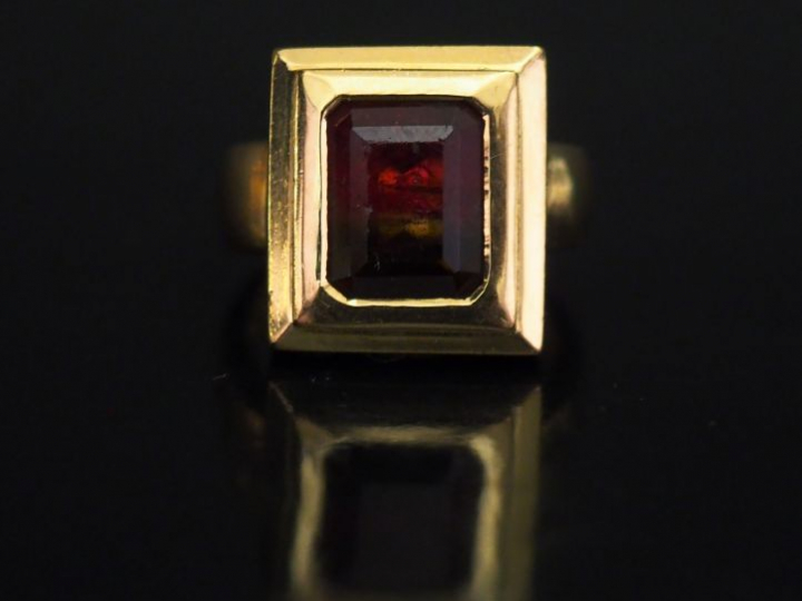 	Bague moderne en or jaune, sertie en son centre d’une pierre bicolore