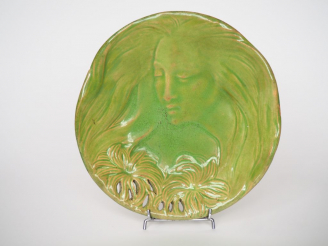 Vente aux enchères Assiette Art nouveau en céramique verte à décor d'une allégorie de flo