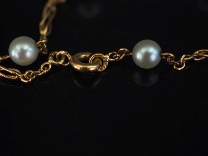 Bracelet souple en or jaune, composé de maillons ovales ajourés et per