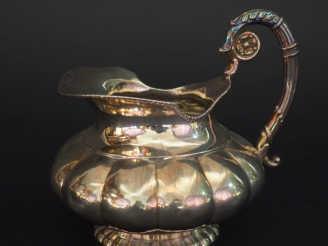Vente aux enchères Petite verseuse en argent étranger, à décor de godrons. Anse feuillagé