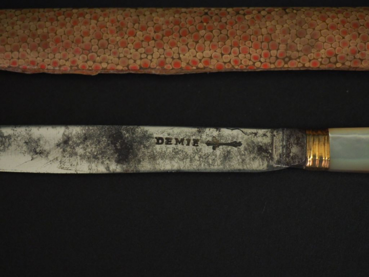 DEMIE. Couteau en métal argenté, doré et nacre, dans son étui en galuc