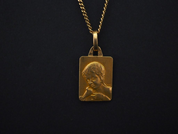 Chaine en or jaune, maille gourmette, ornée d'une médaille en or jaune