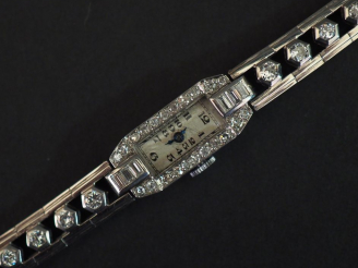 Vente aux enchères Montre de style Art déco en or blanc et diamants.  Boitier à pans coup