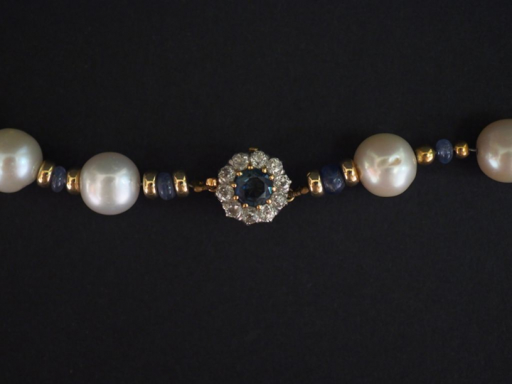 Collier de perles blanches, bleues et or alternées.  Joli fermoir en o