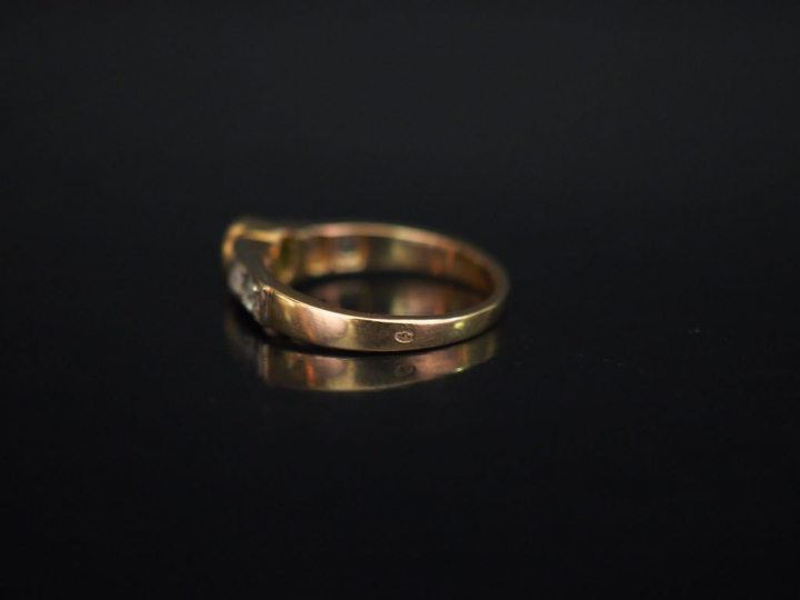 Bague jonc en or jaune, sertie en son centre d'une émeraude épaulée de