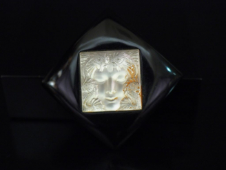 Vente aux enchères LALIQUE Broche en forme de losange en verre noir centrée d'un motif de