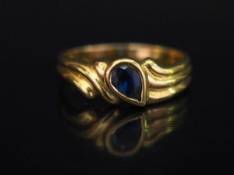 Vente aux enchères Bague en or jaune, sertie en son centre d'une pierre bleue en forme de
